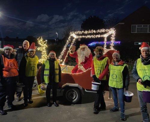 Santa in his merry new sleigh, with volunteers collecting donations.