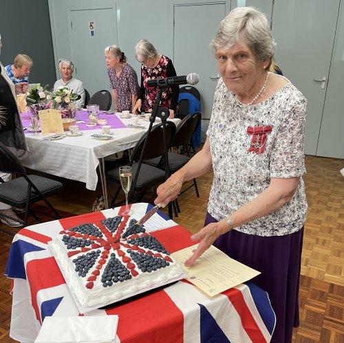 Jean Benbow MBE, Society Member, cuts the jubilee cake.